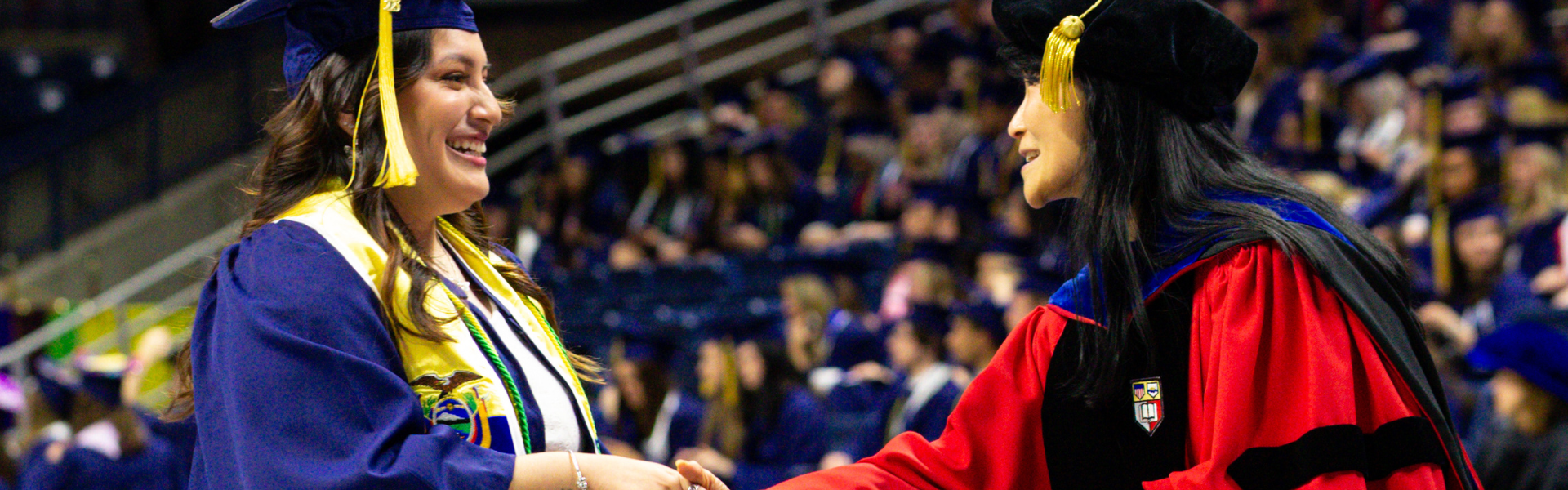 ANSC Department Head Dr. Xiuchun Tian presenting a student with their degree during commencement