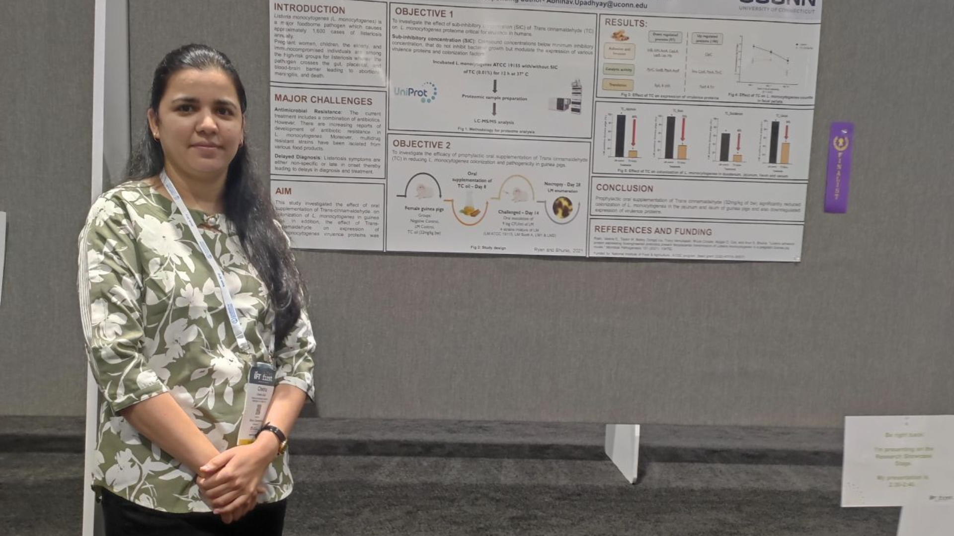 Chetna Shah posing for a photo in front of her research poster.