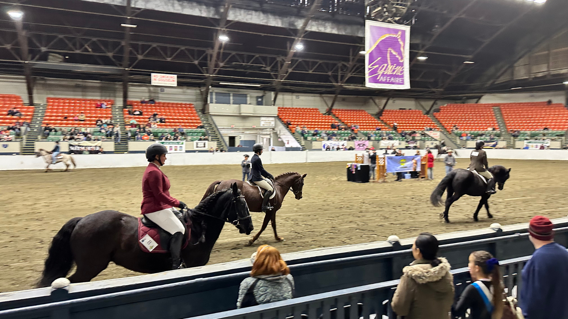 Group horseback riding inside of arena during Equine Affaire