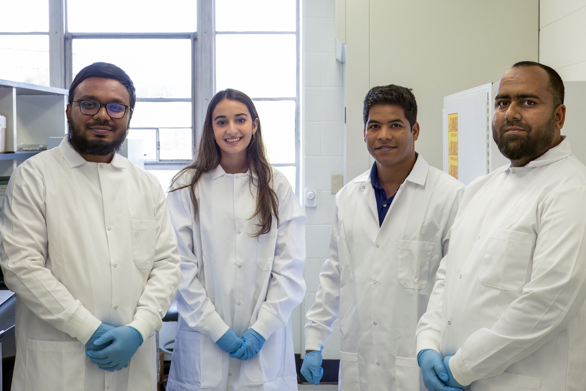 Uddin Lab Posing for Photo in Lab. (Jaran Smith/UConn Photo)