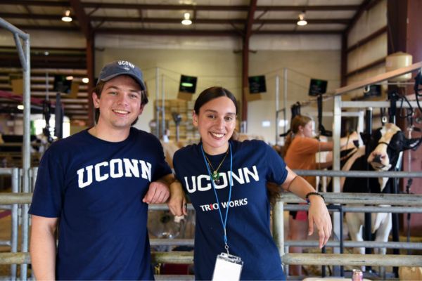 Students posing for photo in dairy cow facility.