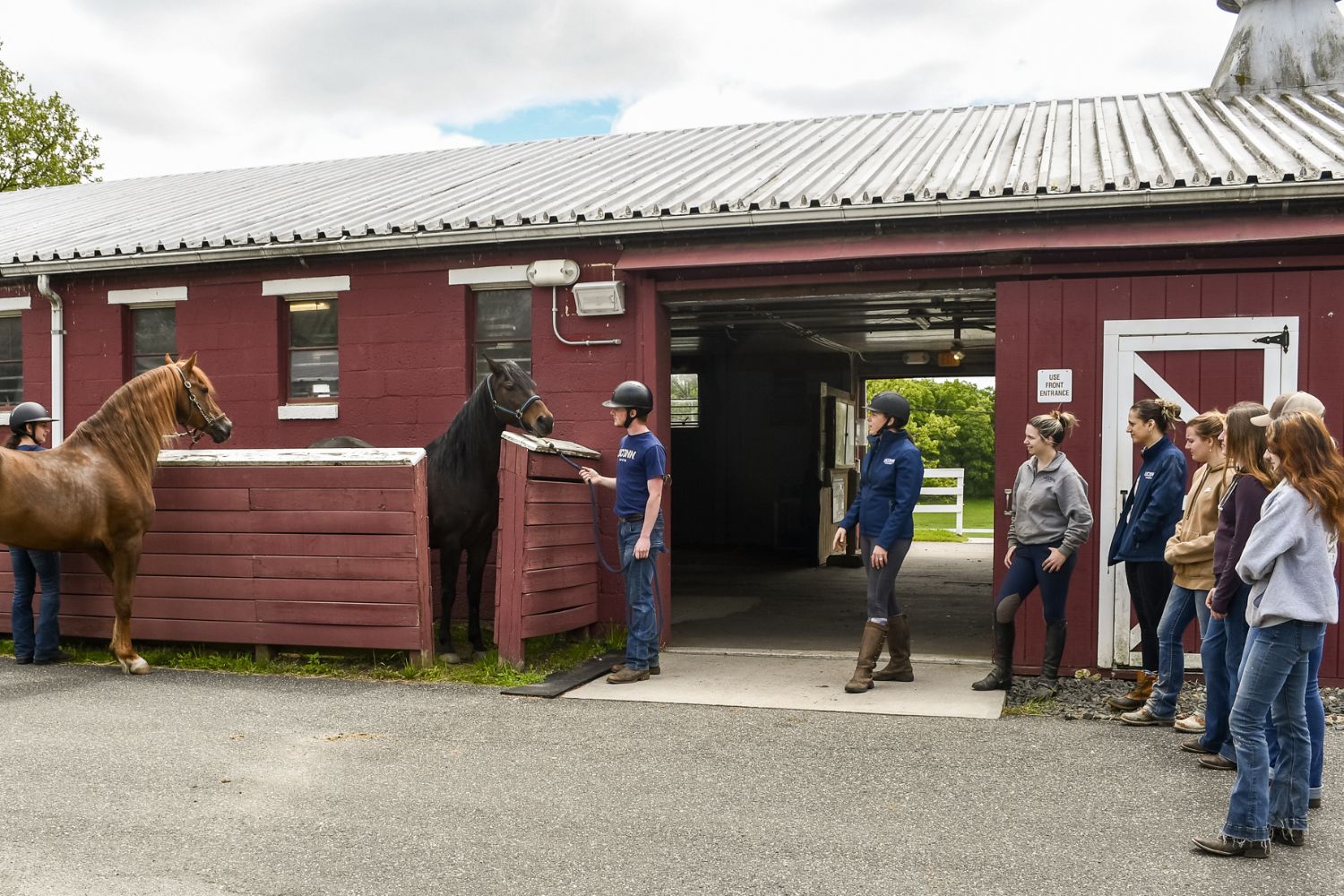Students watching horse demonstration outside of horse unit