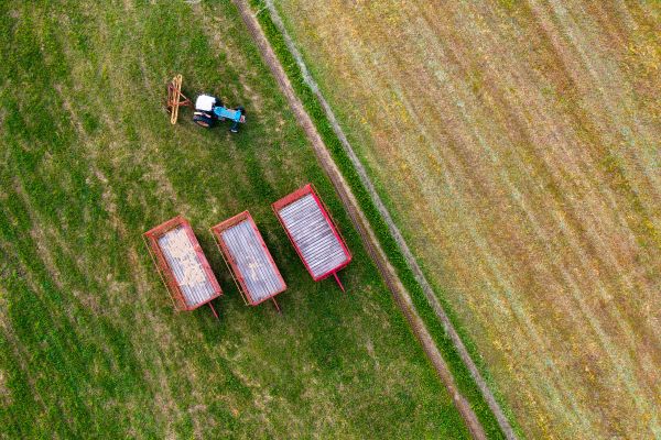 Hay trailers and a tractor looking down from a drone on June 17, 2021