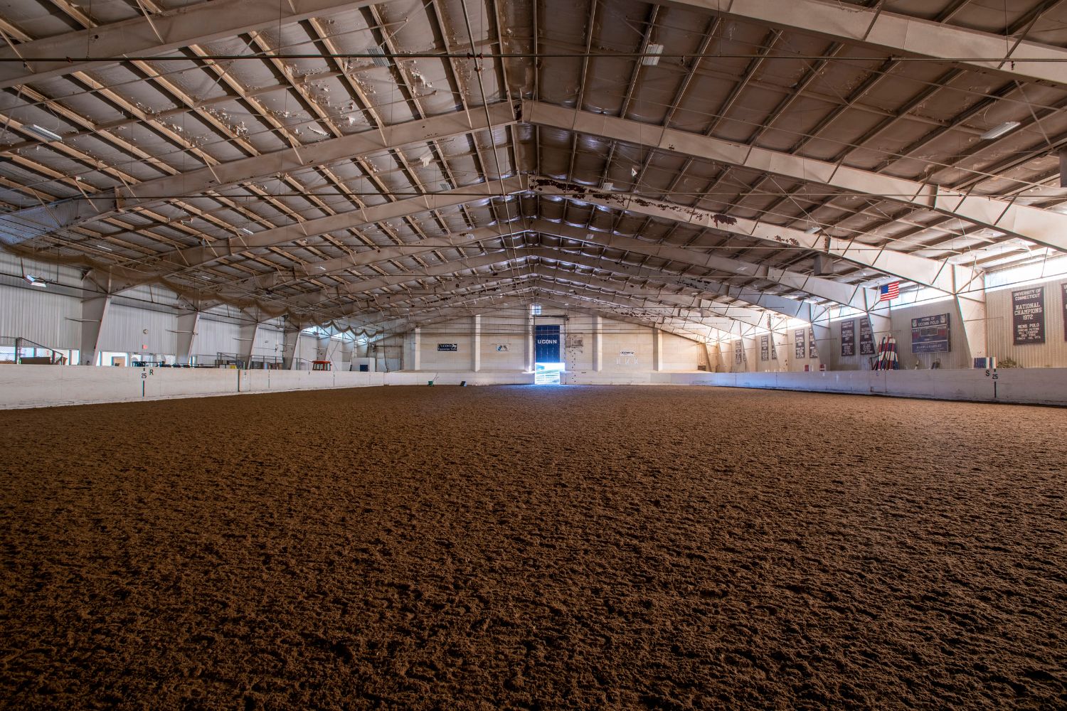 The interior of an empty arena with a dirt floor.