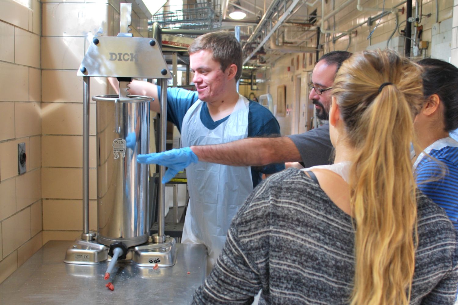 An instructor guides a student on how to use a machine inside of a laboratory.