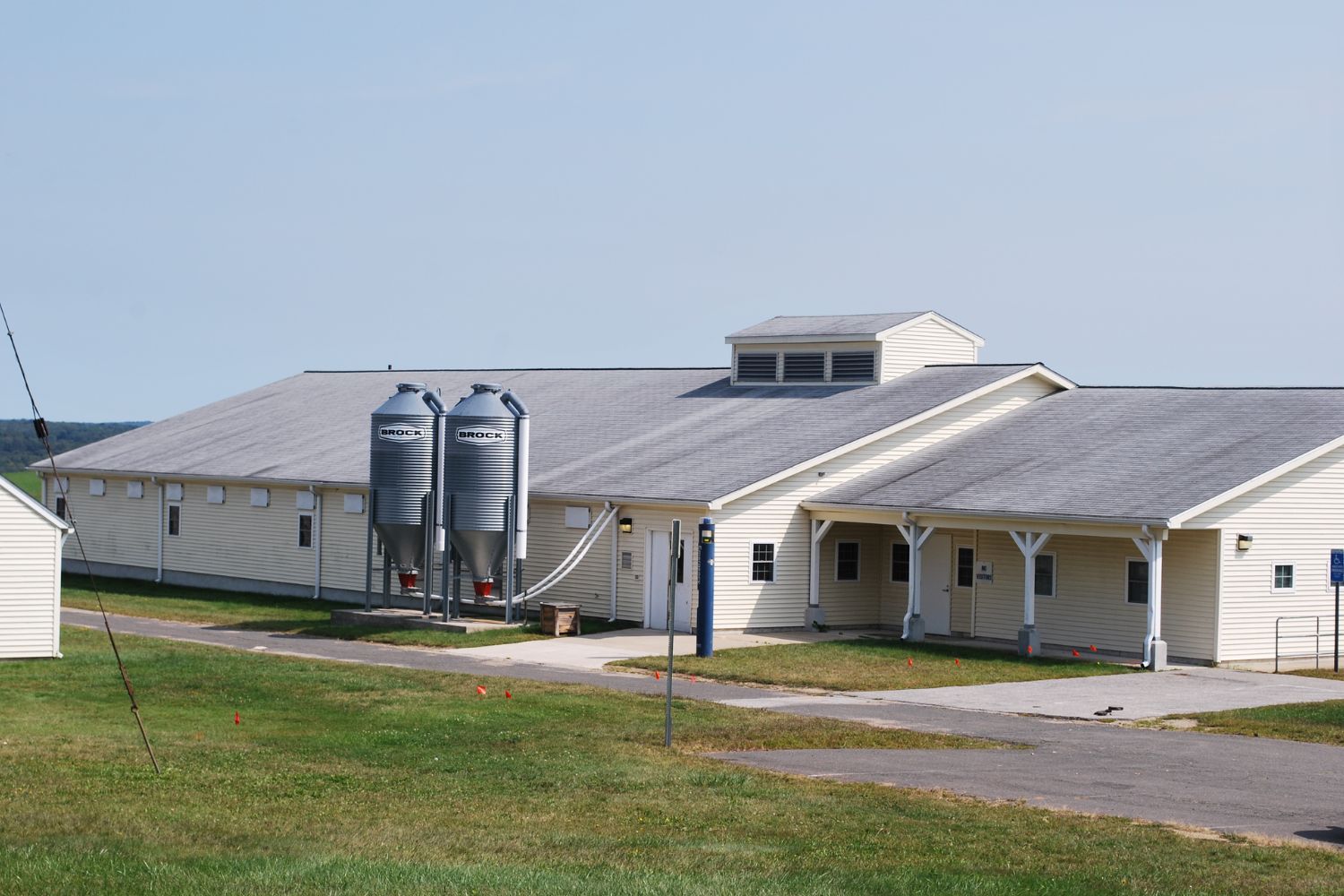 A white building with two feed cylinders on a sunny day.